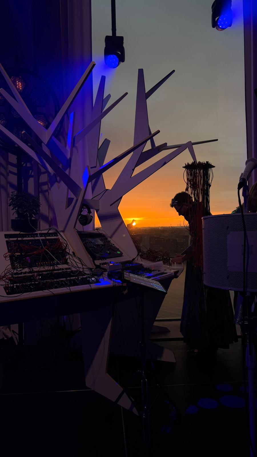 Vox Arboris stage at A'dam Tower — modular rig and white branching tree sculpture, sunset behind
